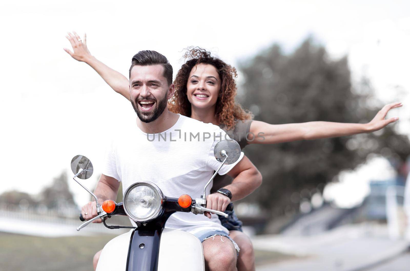 Happy cheerful couple riding vintage scooter. Travel concept.