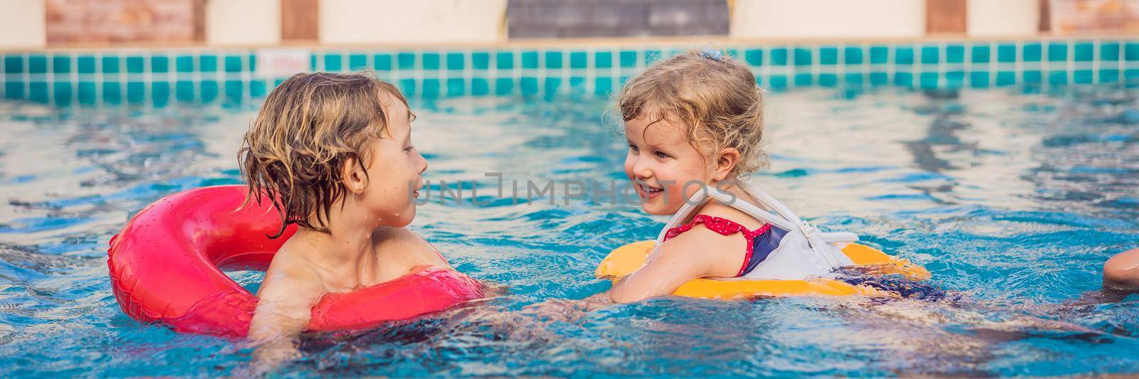 two little kids playing in the swimming pool. BANNER, LONG FORMAT