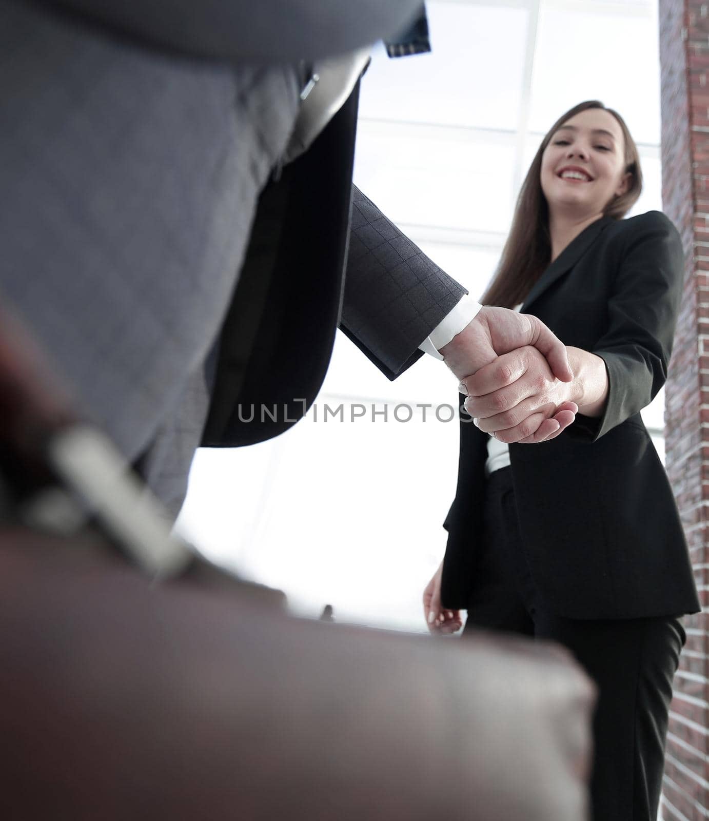 Close up of businessman and businesswoman shaking hands by asdf