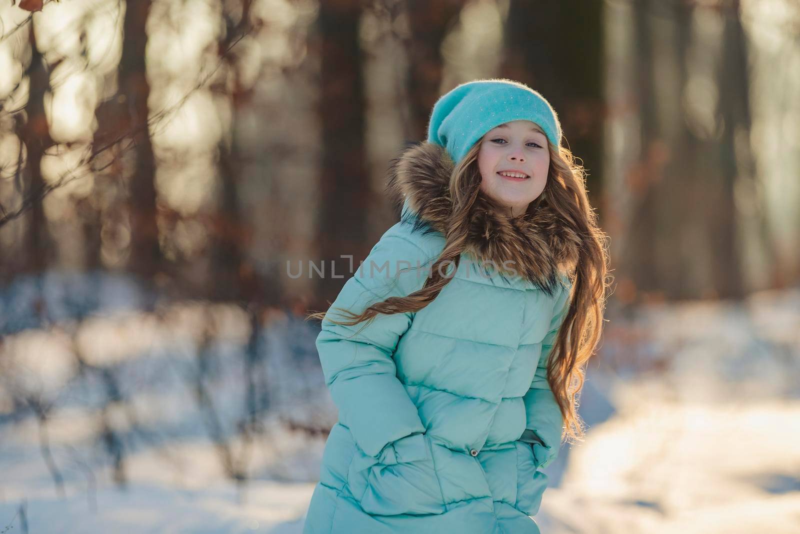 happy girl in turquoise jacket and hat