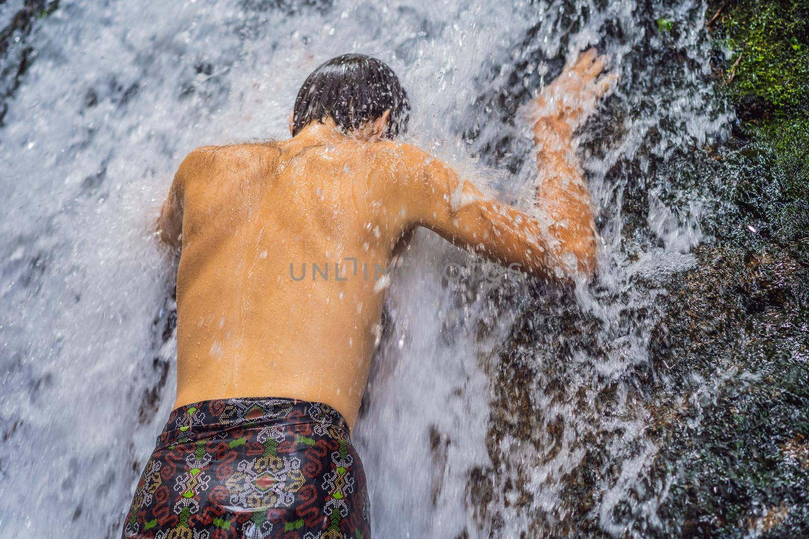 Young man tourist in Holy springs Sebatu in Bali.