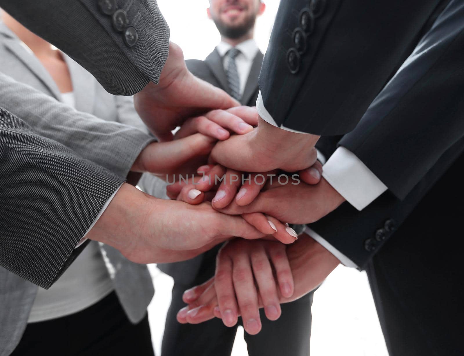 closeup.business people folding their hands together.