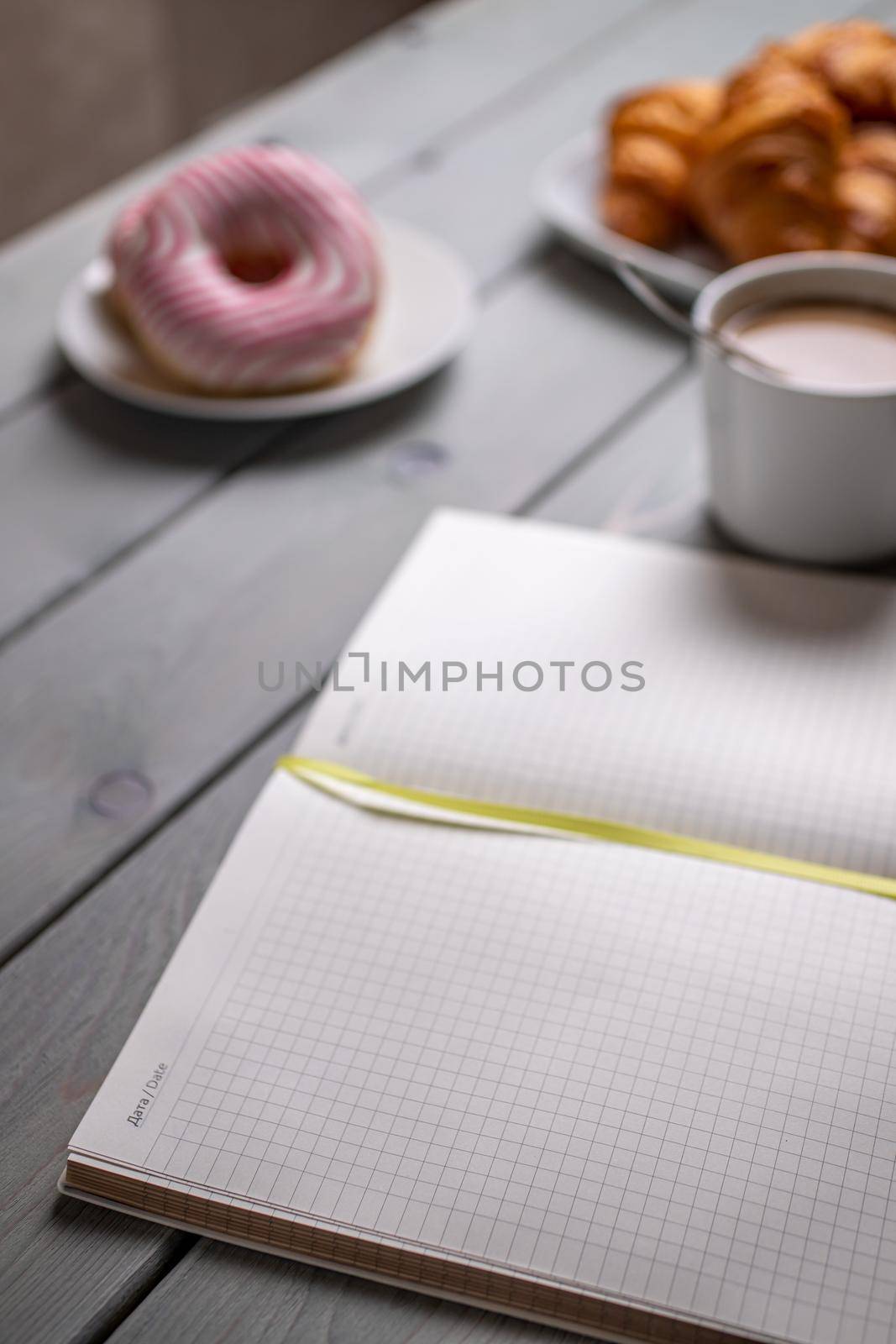 Coffee with milk and croissants and a notepad. Selective focus by bySergPo