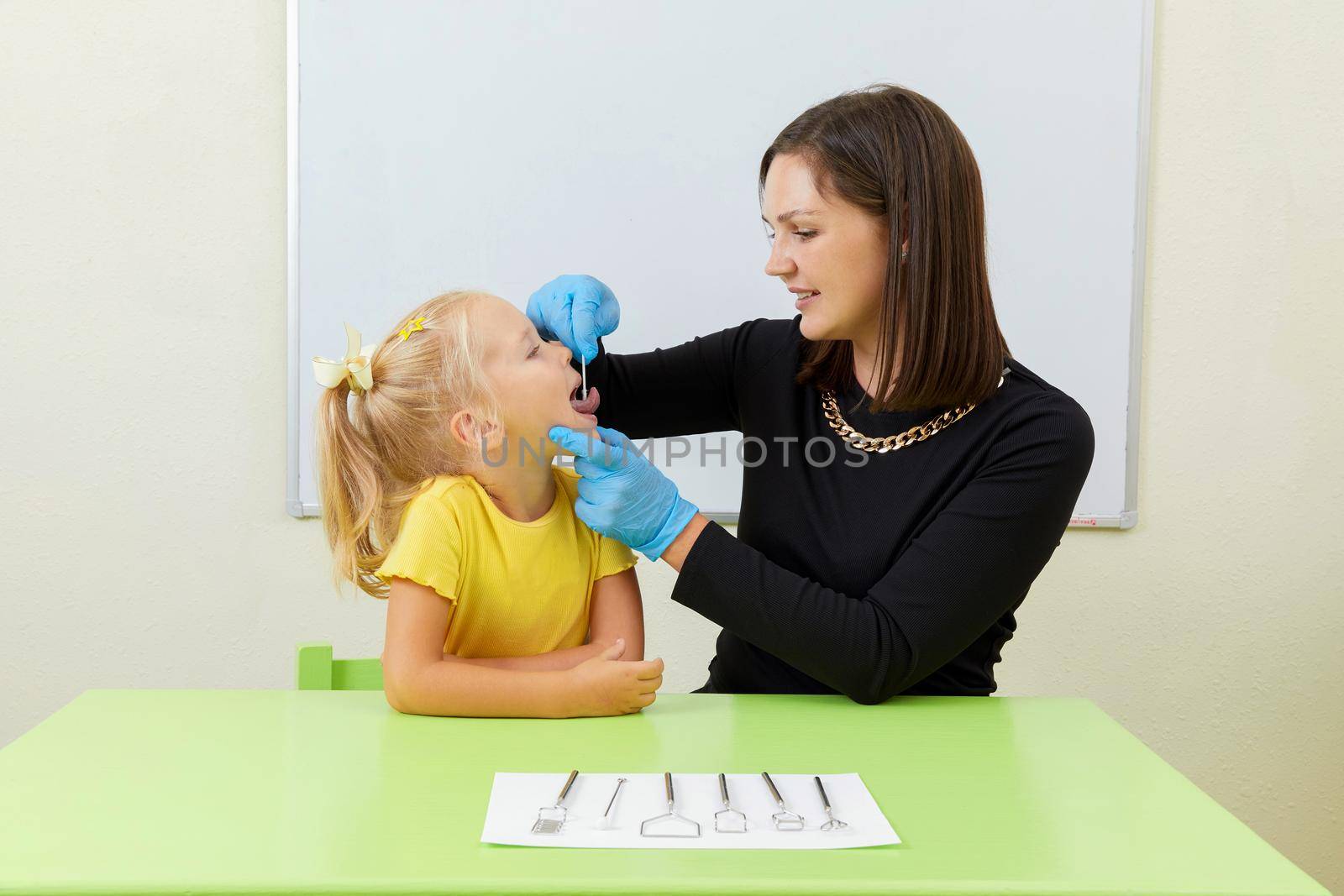 Speech therapist working with little girl in office training pronunciation by Mariakray