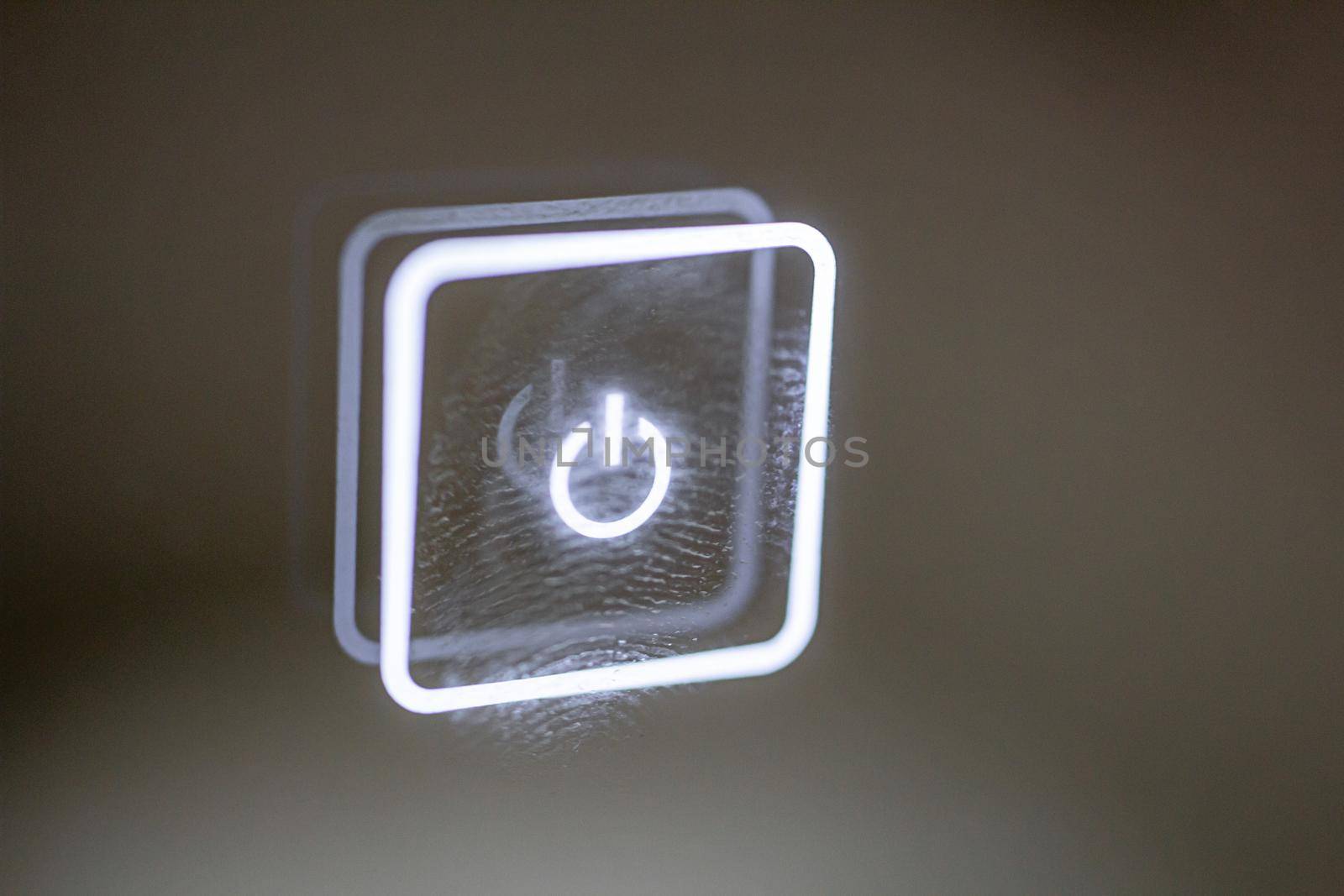 a glowing touch button stained with finger marks. turn on off. copy space