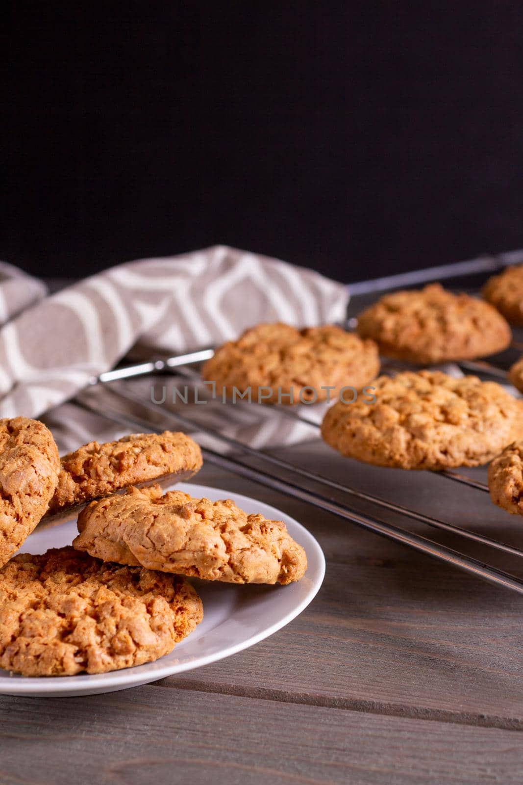freshly baked warm oatmeal cookies on a cooling rack by bySergPo