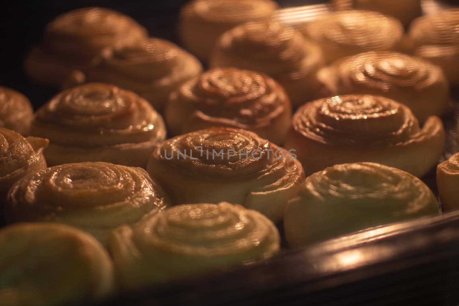 baking sweet buns in the oven close-up. the selected focus. by bySergPo