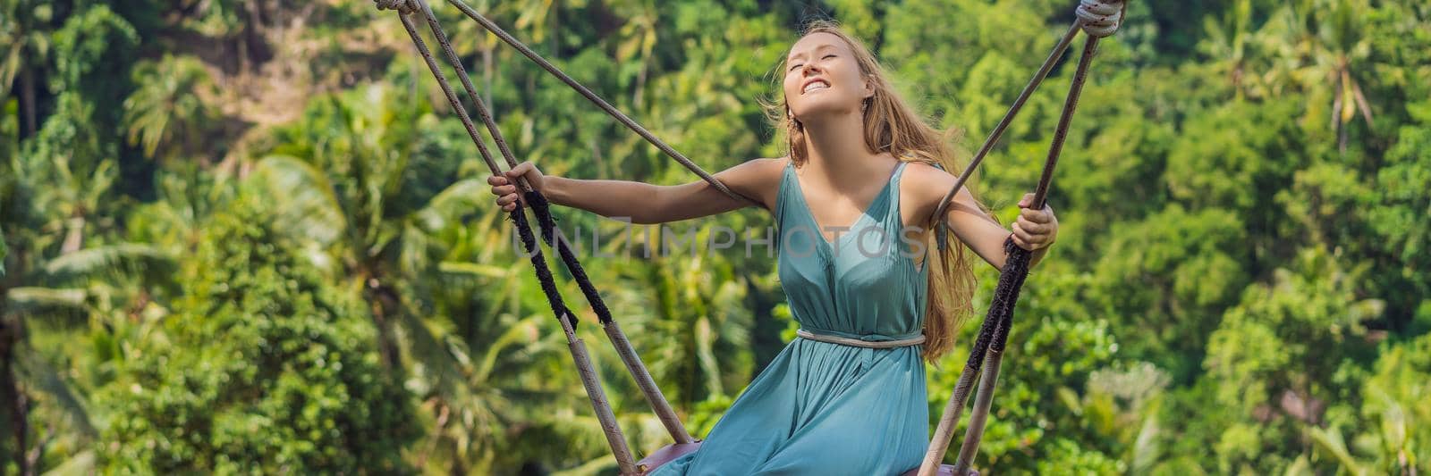 Young woman swinging in the jungle rainforest of Bali island, Indonesia. Swing in the tropics. Swings - trend of Bali BANNER, LONG FORMAT by galitskaya