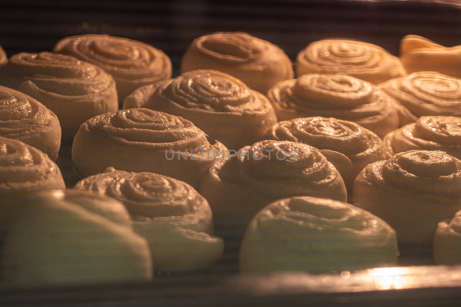baking sweet dough buns in the oven close-up. the selected focus.