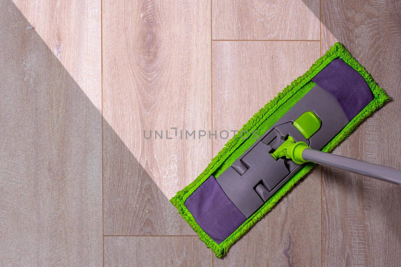 cleaning of the apartment-a sweeper with a wet mop on dirty laminate floors.
