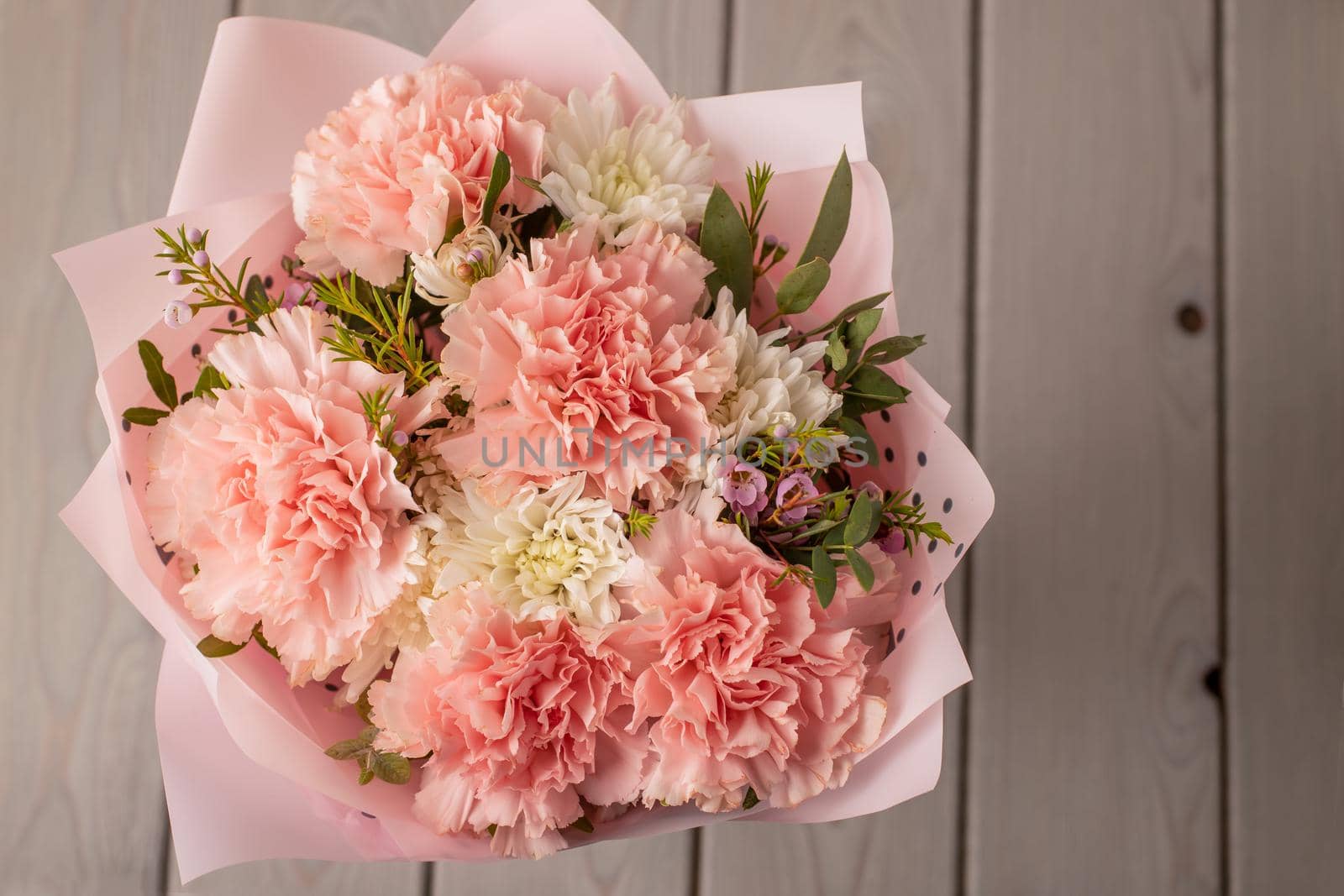 Beautiful fresh spring flowers on a wooden table, top view. Delicate pastel tone of the image.