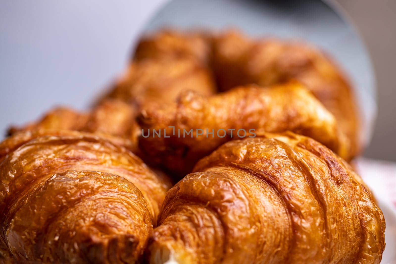 Croissants close-up. Delicious hot fresh pastries. View of croissants with a reflected background. The selected focus.