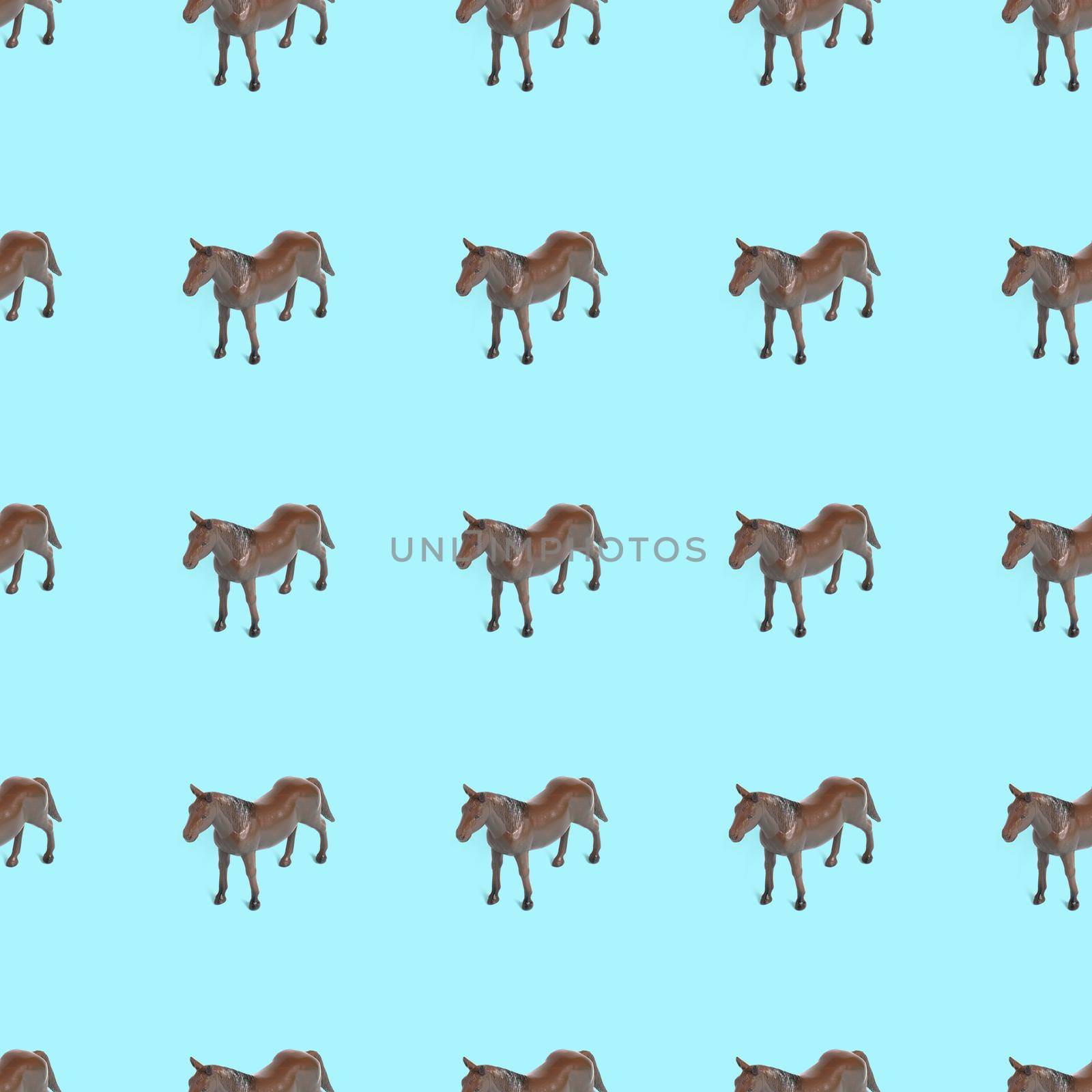Seamless pattern photo of a toy horse on a blue background creative illustration.