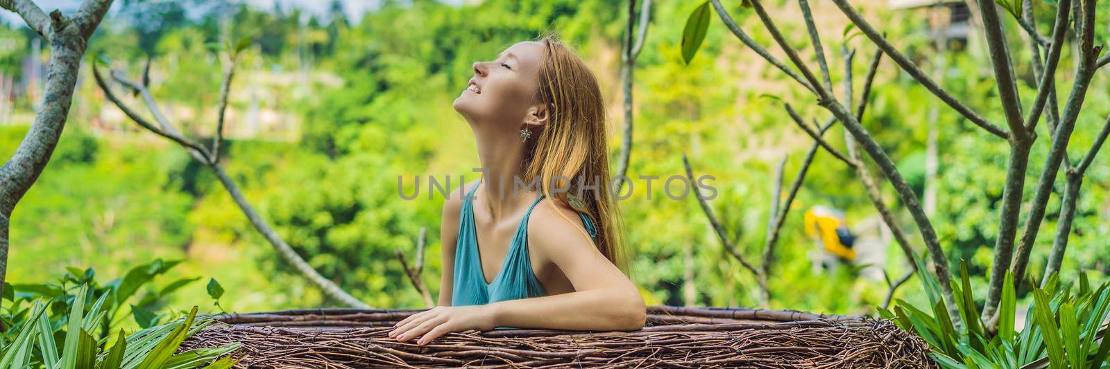 BANNER, LONG FORMAT Bali trend, straw nests everywhere. Young tourist enjoying her travel around Bali island, Indonesia. Making a stop on a beautiful hill. Photo in a straw nest, natural environment. Lifestyle.