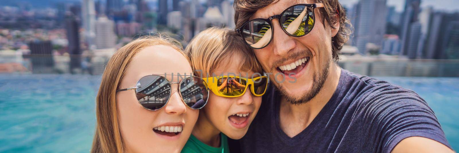 Vacation and technology. Happy family with kid taking selfie together near swimming pool with panoramic views of the city BANNER, LONG FORMAT by galitskaya