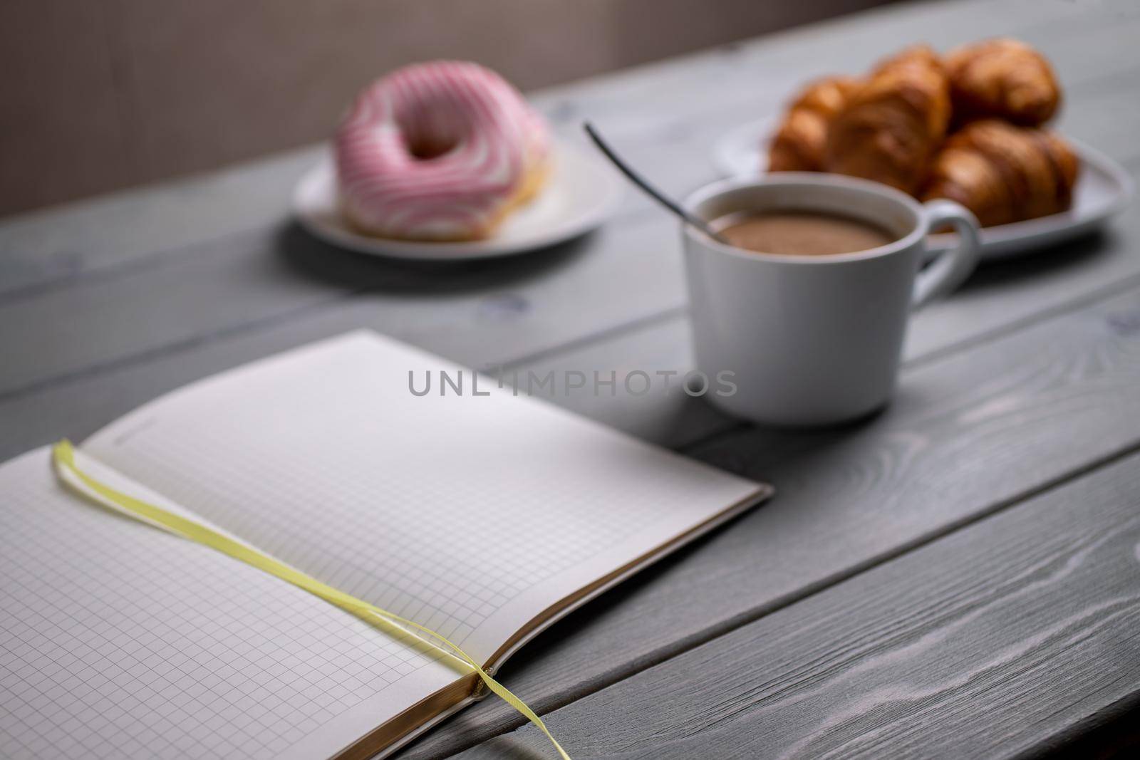Coffee with milk, croissants and a notebook. Selective focus. The concept of morning planning
