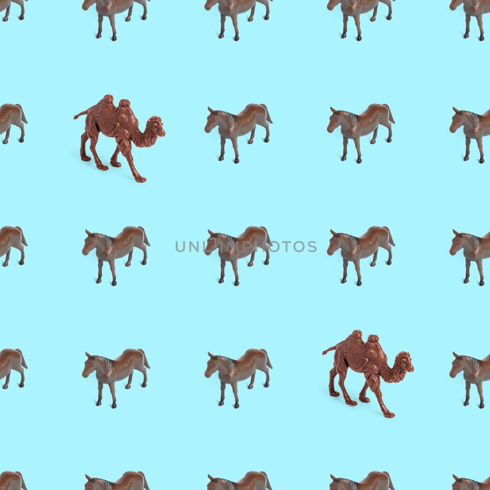 Seamless pattern photo of a toy horse and camel on a blue background. by bySergPo