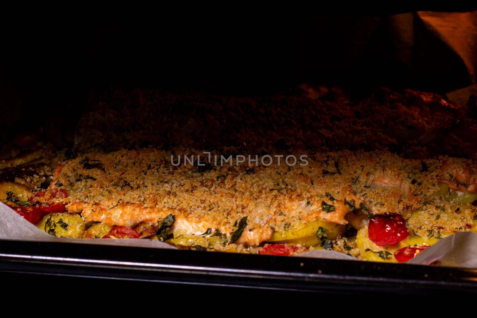 Trout with vegetables, bread crumbs with hard cheese, and potatoes cooked in the oven