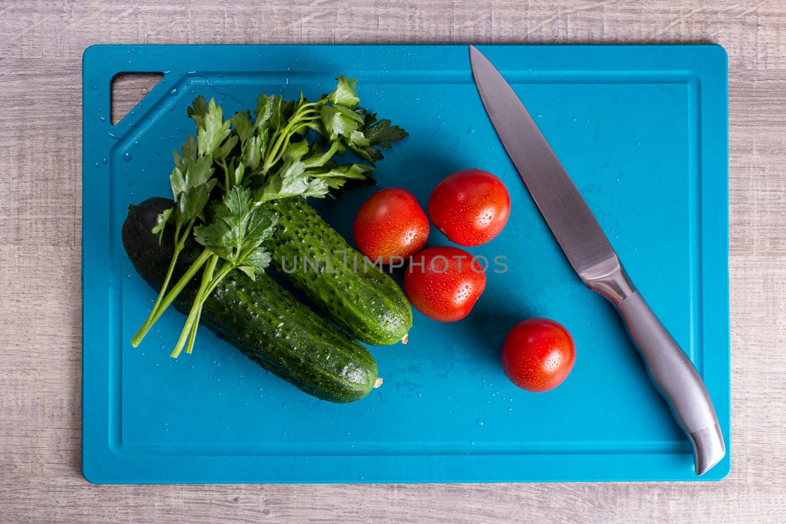 top view of vegetables in the form of cucumber and tomato with a knife by bySergPo
