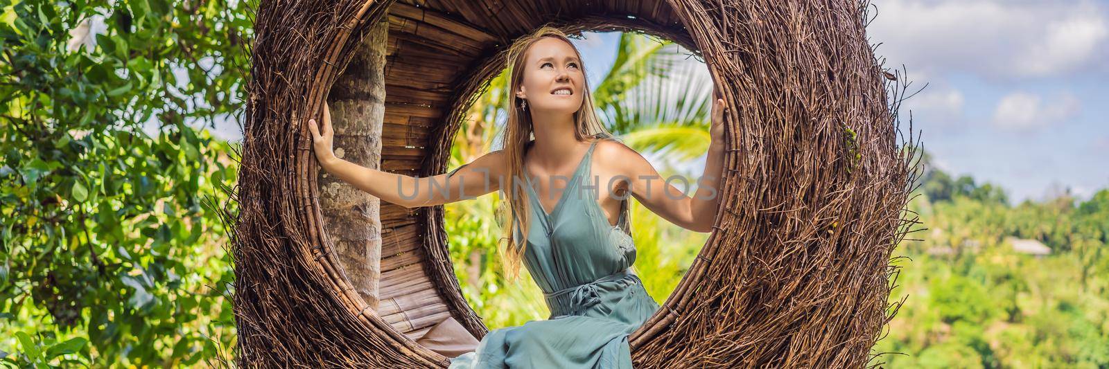 BANNER, LONG FORMAT Bali trend, straw nests everywhere. Young tourist enjoying her travel around Bali island, Indonesia. Making a stop on a beautiful hill. Photo in a straw nest, natural environment. Lifestyle.