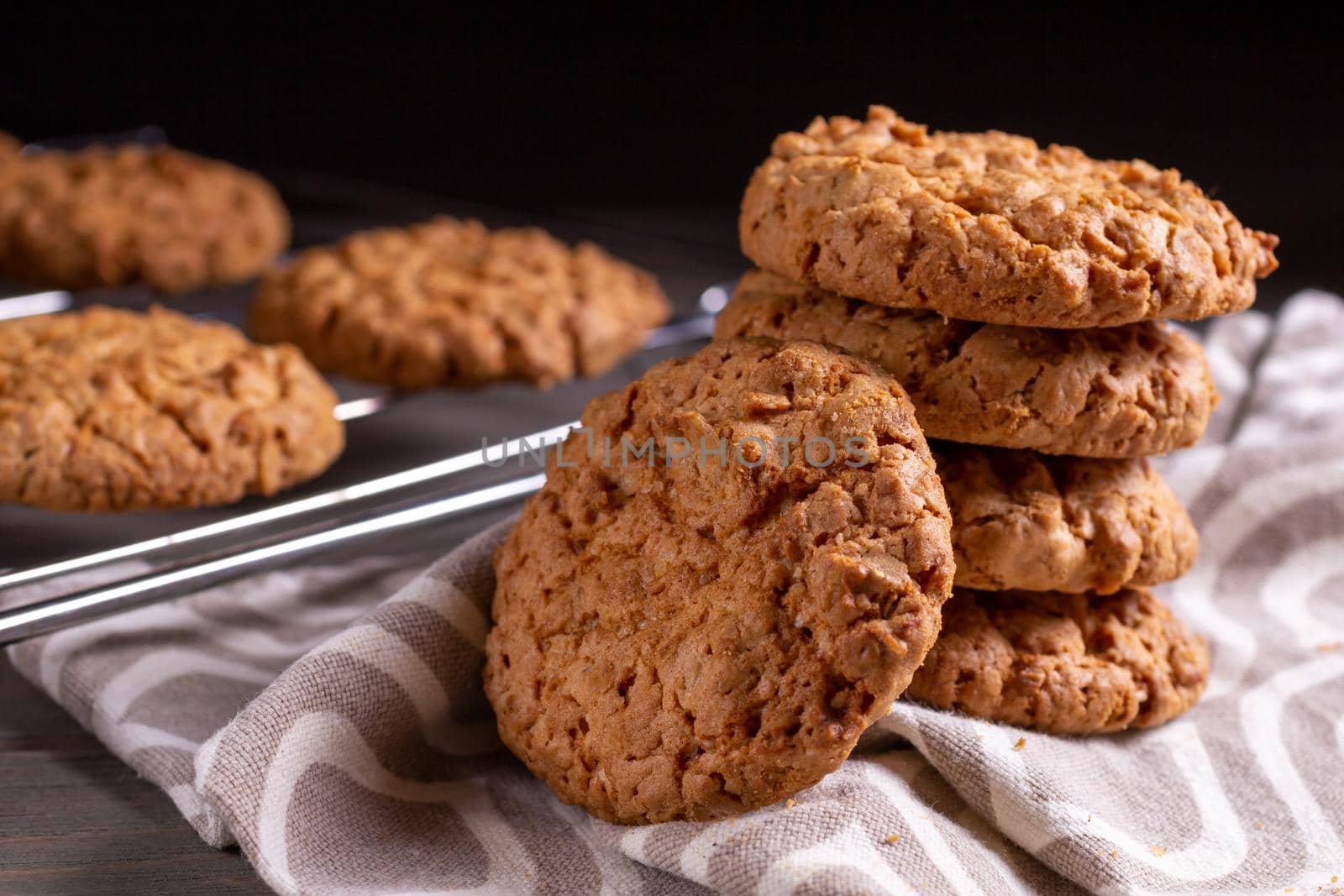 A stack of oatmeal cookies in a saucer on a wooden table by bySergPo