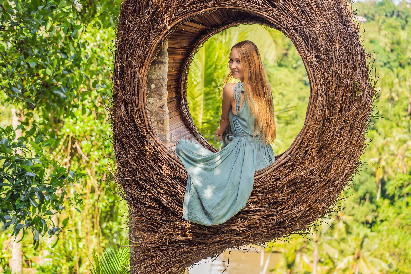 Bali trend, straw nests everywhere. Young tourist enjoying her travel around Bali island, Indonesia. Making a stop on a beautiful hill. Photo in a straw nest, natural environment. Lifestyle.