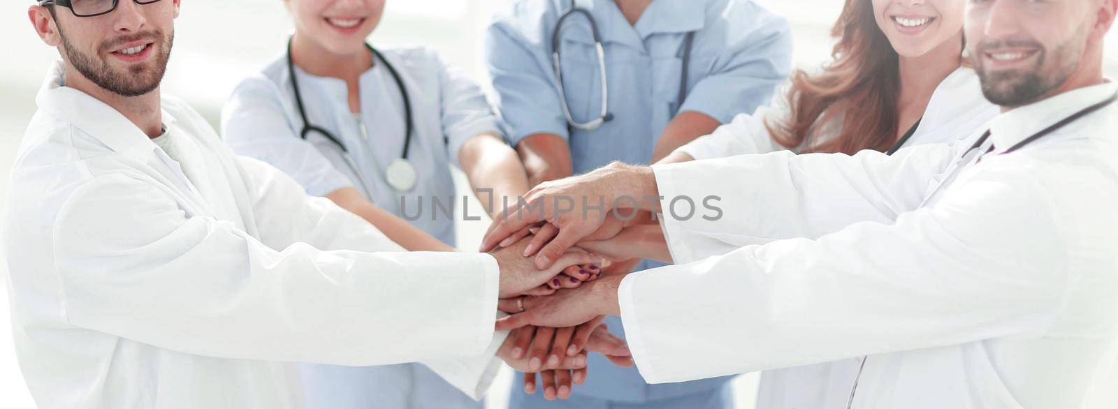 Doctors and nurses stacking hands. concept of mutual aid. by asdf