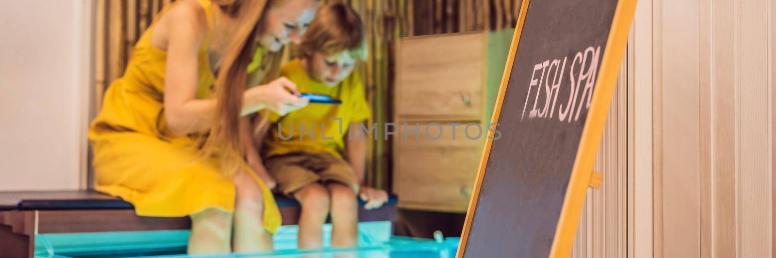 Mom and son at the fish spa. BANNER, LONG FORMAT