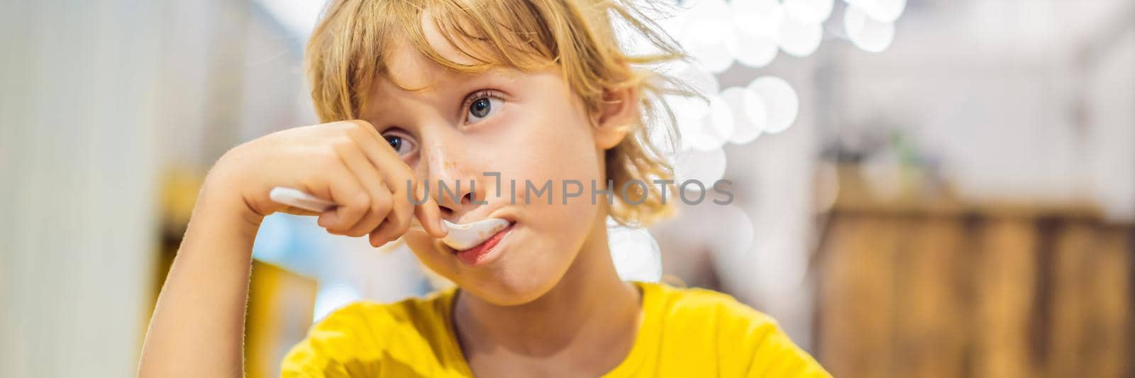 Boy eating ice cream in a cafe. BANNER, LONG FORMAT