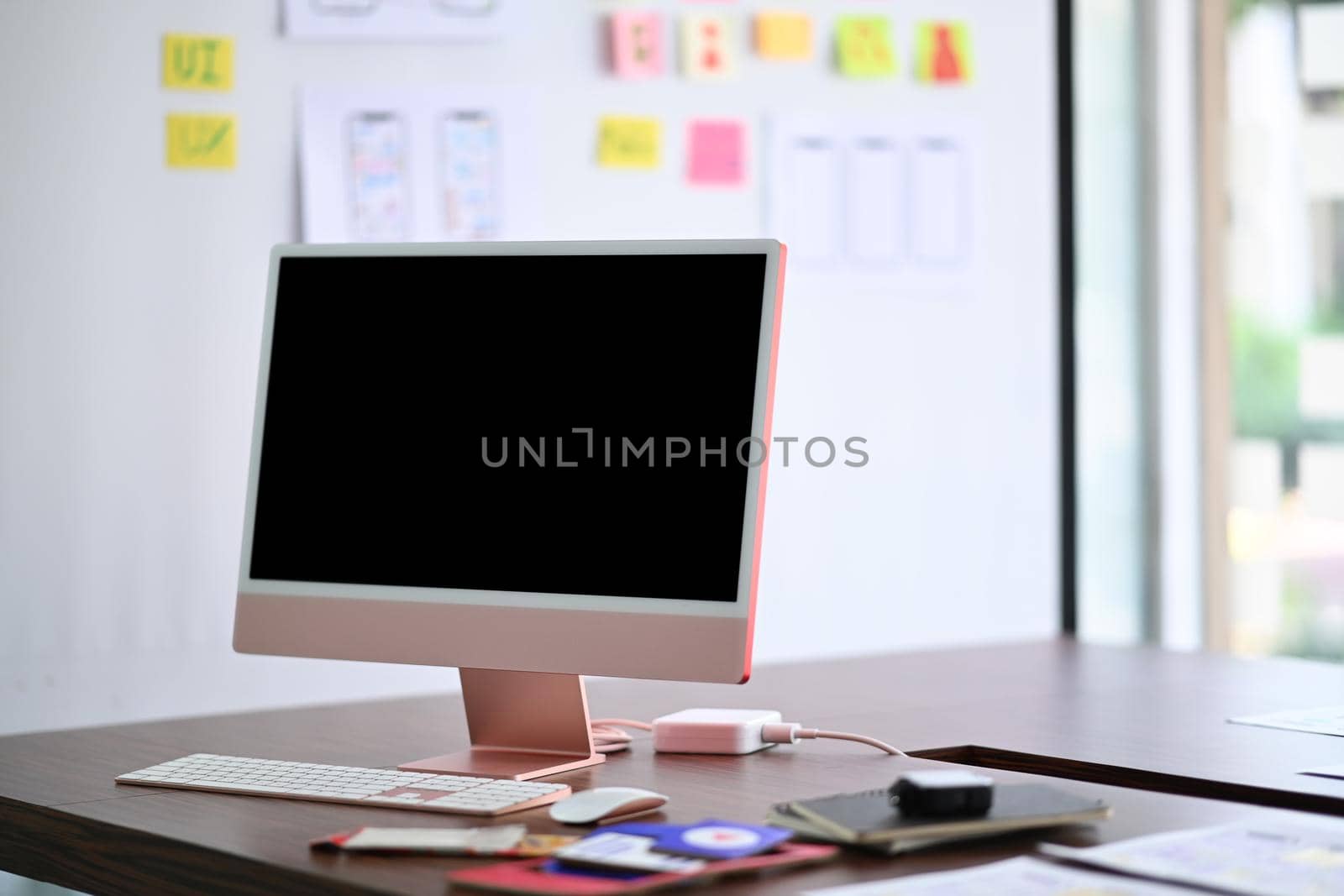 Modern workplace with computer, stationery and paperworks on wooden table.