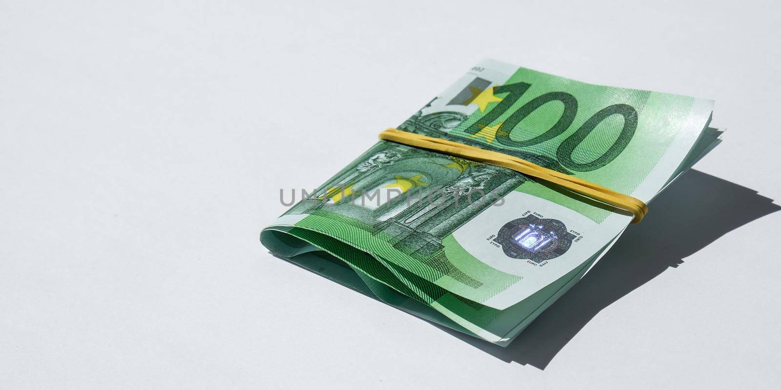 Close up of Euro money roll. Euro banknote set cash money - EU currency. Rolled with rubber euro notes. Business budget of wealth and prosperity finance. Banknotes stacked on each other in different positions.