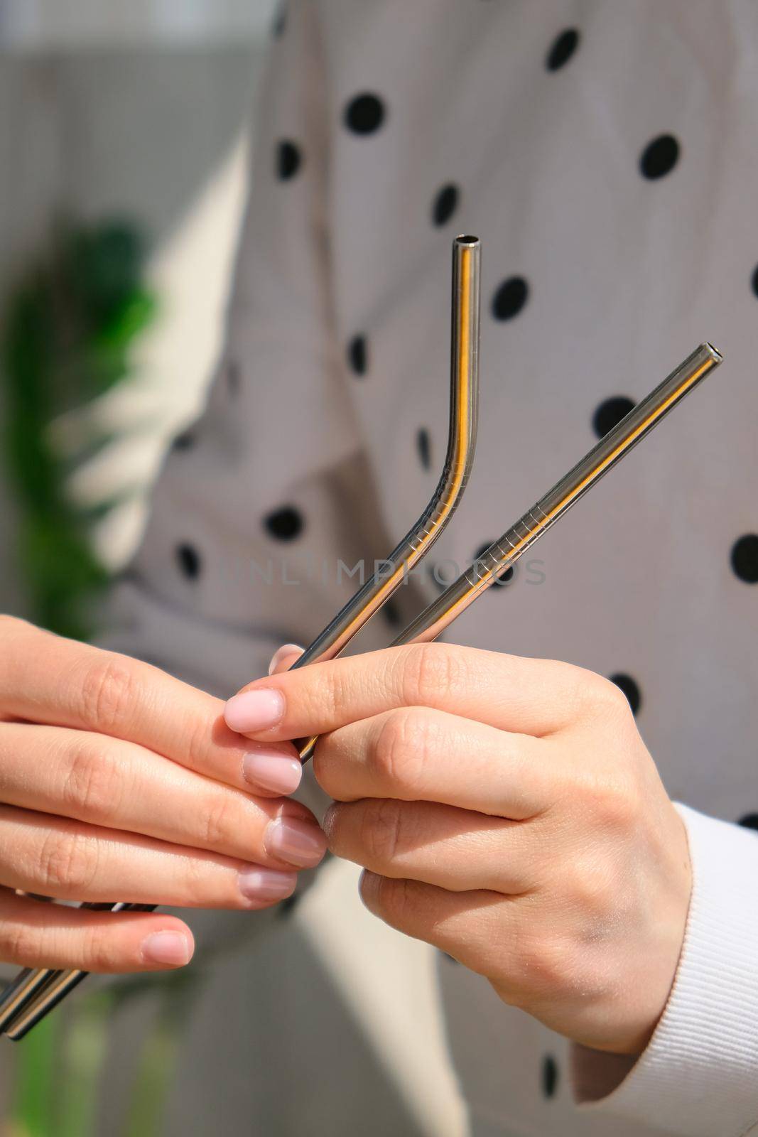 Woman holding Reusable Metal Straw. Female Hand on reusable collapsible drinking straw. Eco lifestyle and zero waste concept. Plastic free. Stainless metal straws