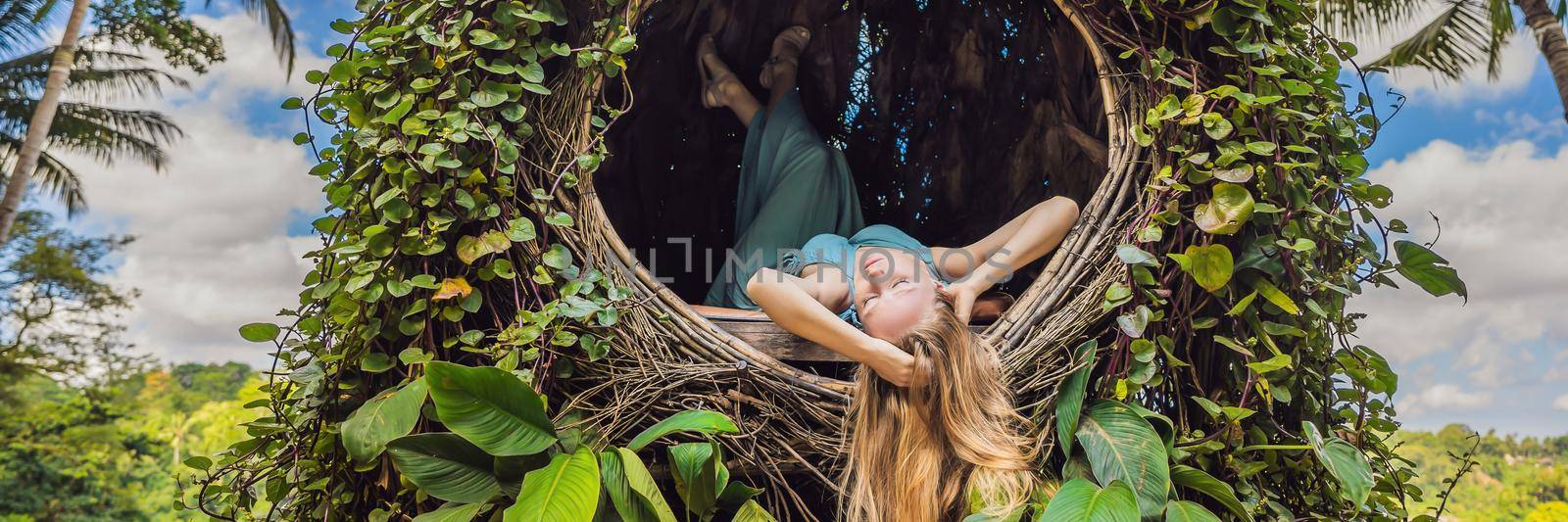 BANNER, LONG FORMAT Bali trend, straw nests everywhere. Young tourist enjoying her travel around Bali island, Indonesia. Making a stop on a beautiful hill. Photo in a straw nest, natural environment. Lifestyle.