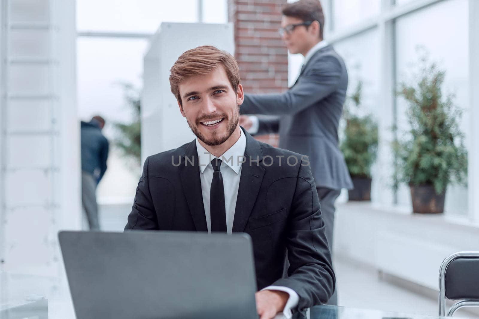 close up. smiling business men sitting at his Desk. people and technology