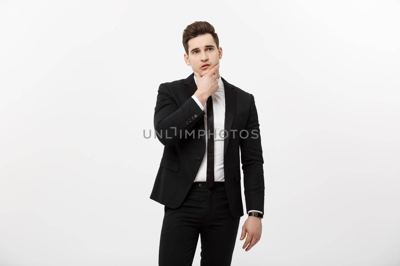 Business Concept: Young handsome man in black suit looking at copy-space smiling, thinking or dreaming by Benzoix