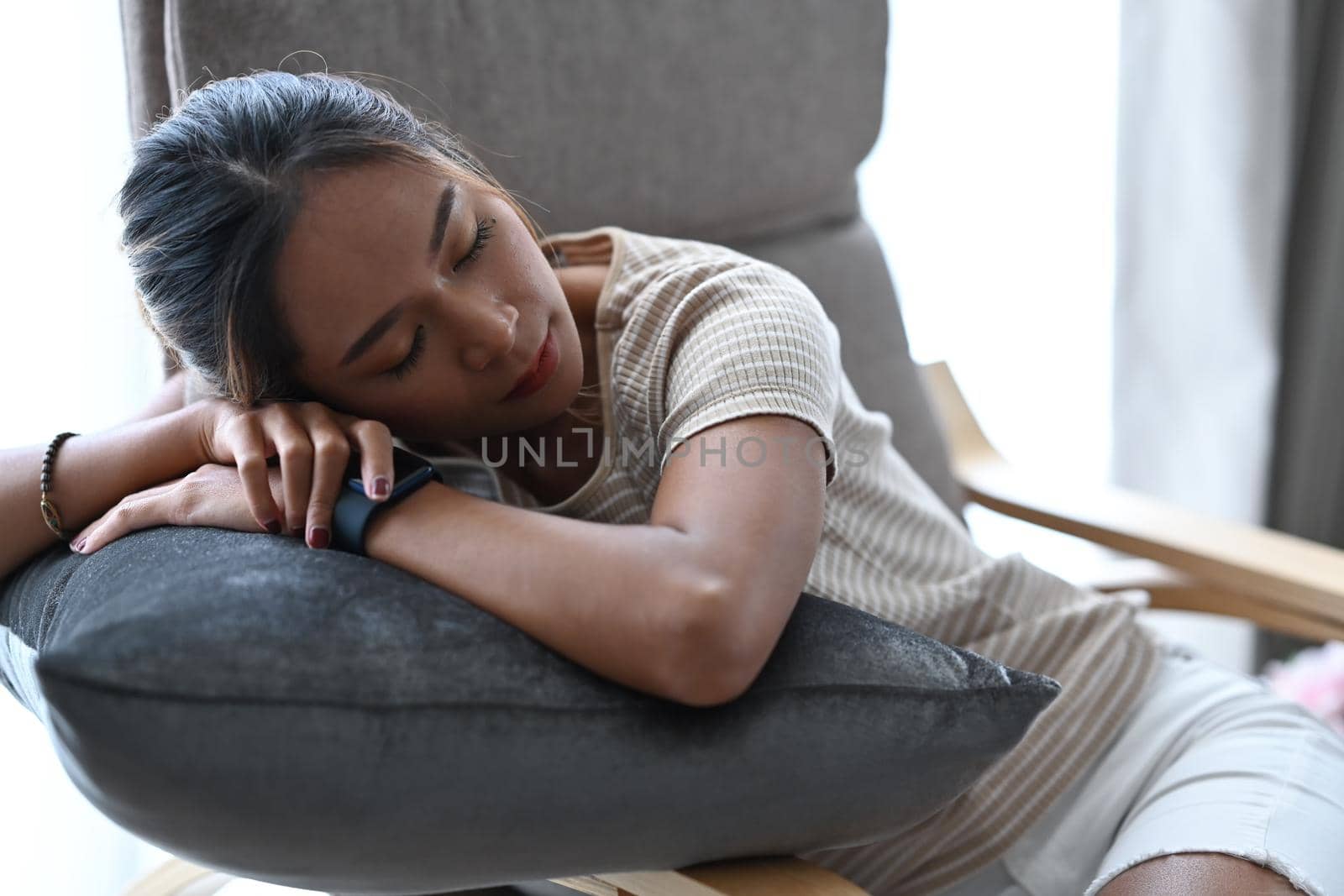 Millennial woman in casual clothes sleeping on comfortable armchair at home.