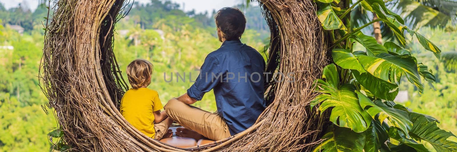 BANNER, LONG FORMAT Bali trend, straw nests everywhere. Child friendly place. Happy family enjoying their travel around Bali island, Indonesia. Making a stop on a beautiful hill. Photo in a straw nest, natural environment. Lifestyle. Traveling with kids concept. What to do with children by galitskaya