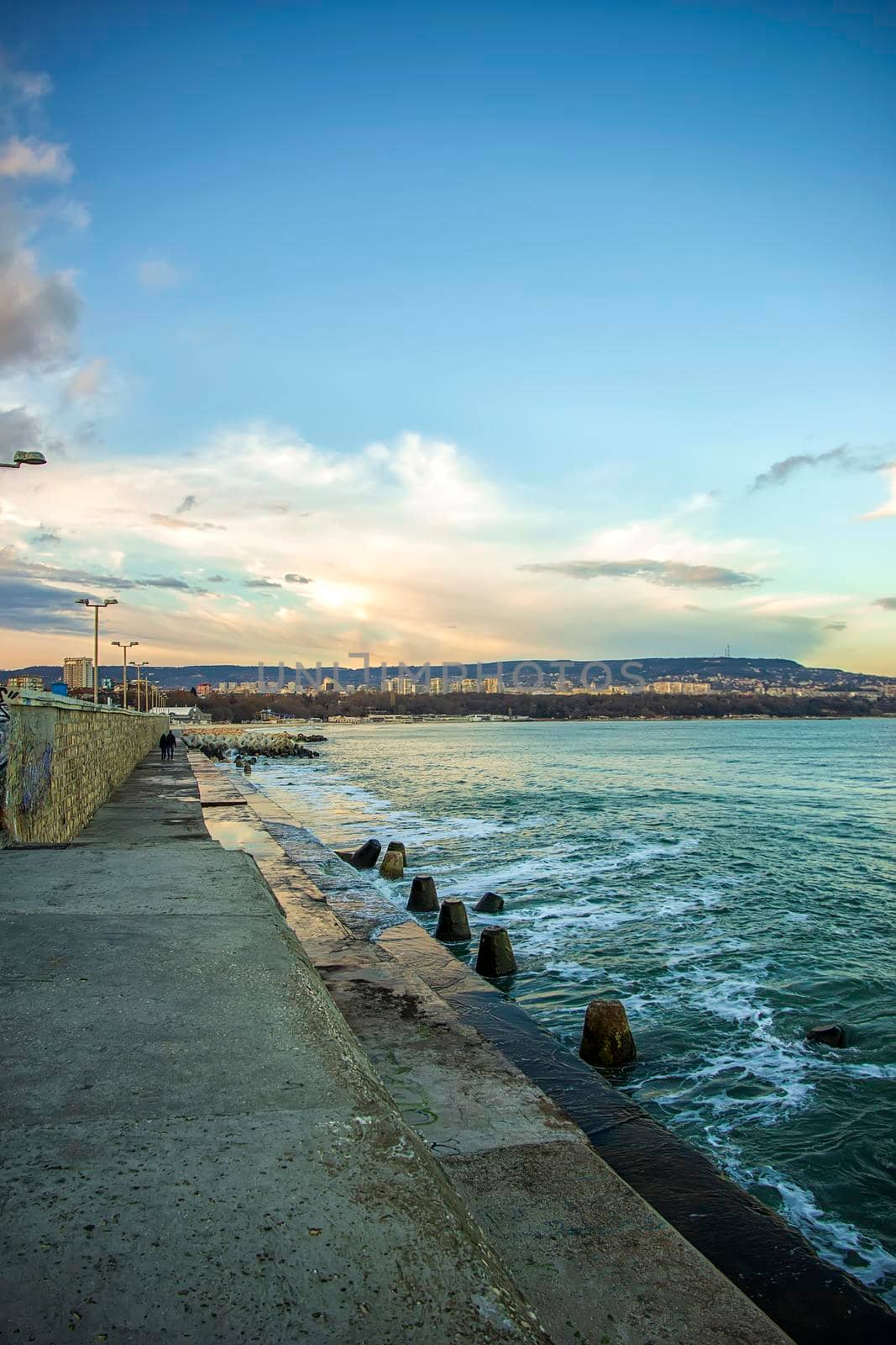 Concrete city breakwater and waves at the black sea. Varna, Bulgaria. Vertical view by EdVal