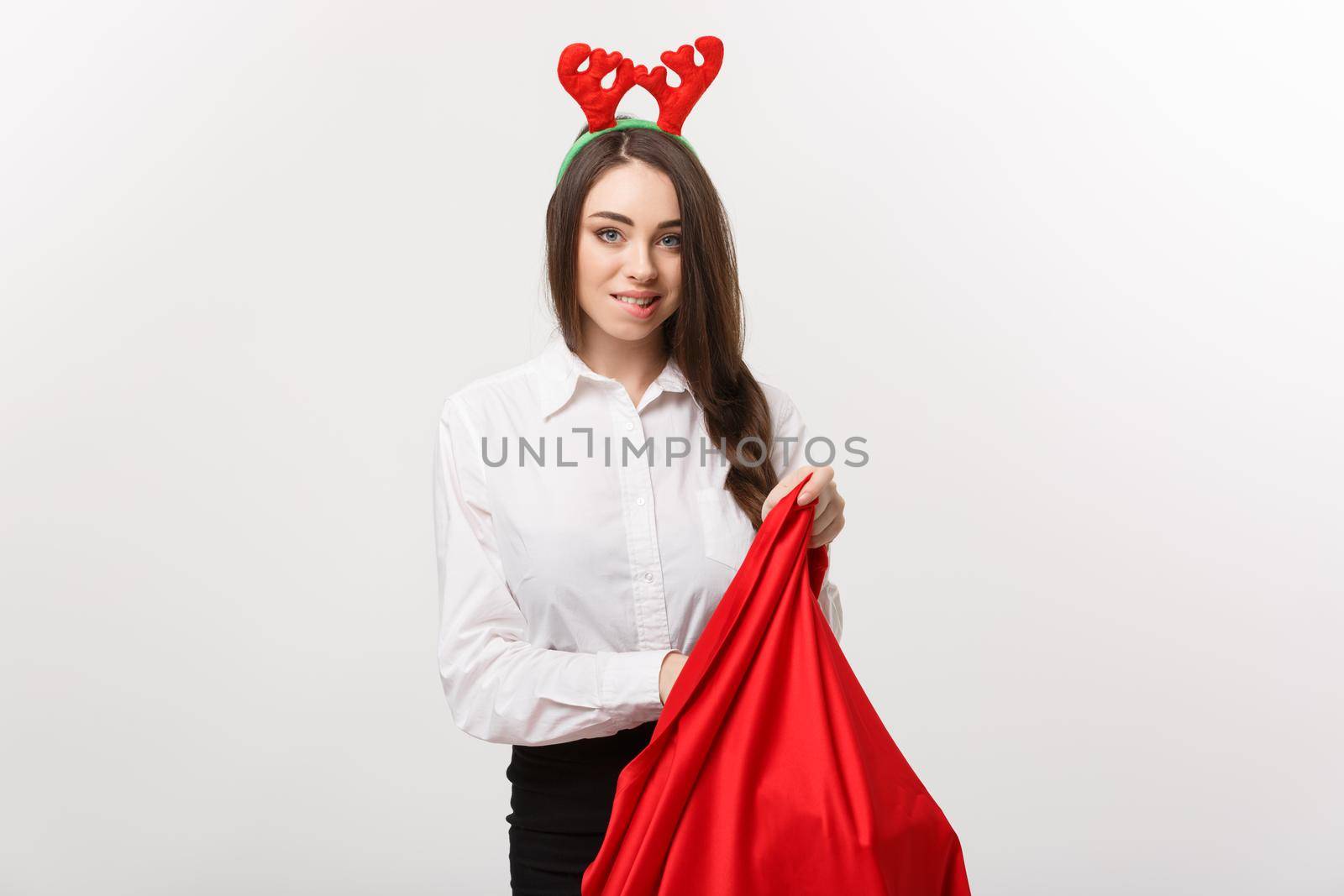 Christmas Concept - Young beautiful business woman excite with present in santa bag.