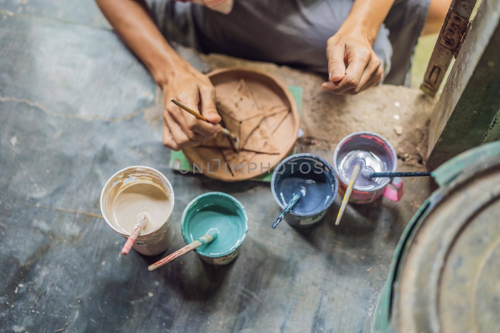 mother and son doing ceramic pot in pottery workshop by galitskaya