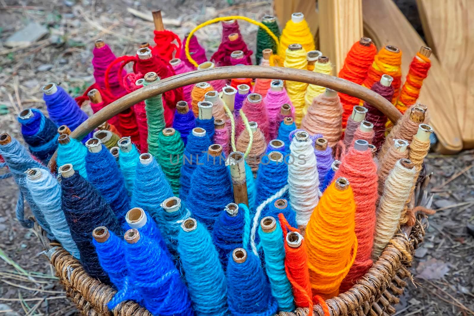 Colored thread spools of thread, textiles, background. Set of colored threads for sewing in a basket.