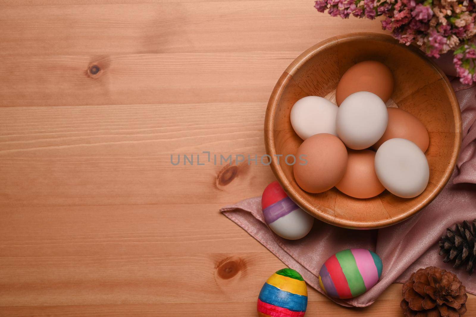 Painted Easter eggs with spring flowers on wooden background. Happy Easter concept.