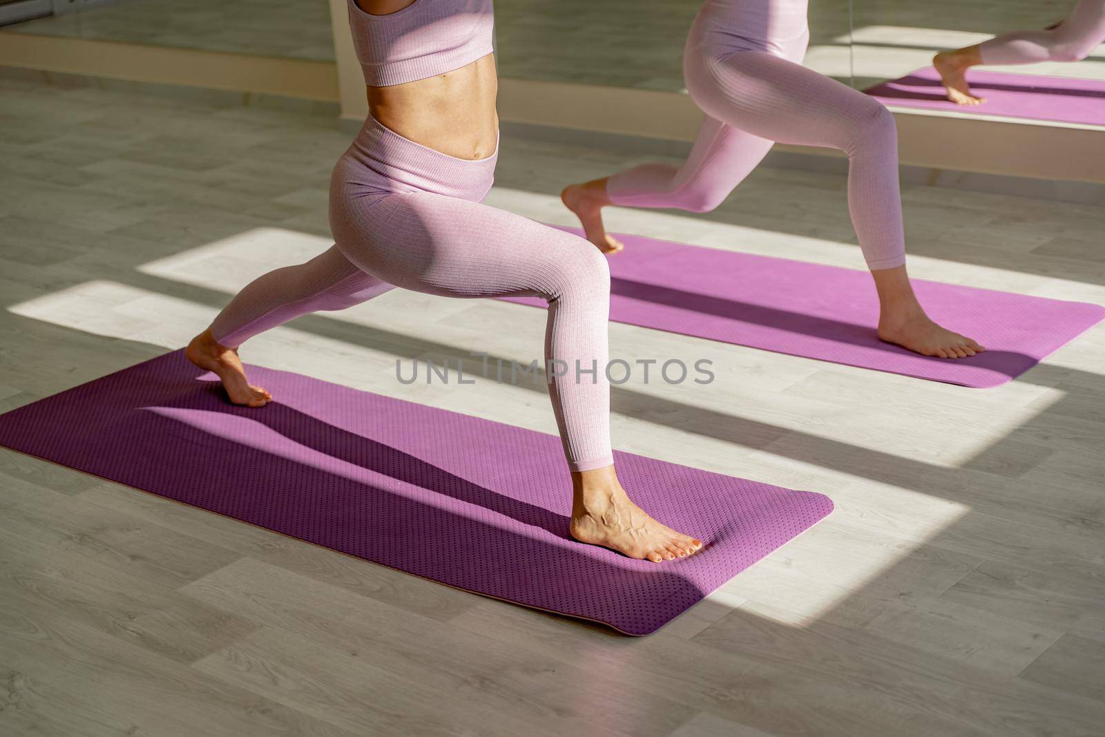 Two beautiful women cook doing yoga, sports together in the gym. Dressed in pink suits. The concept of grace and beauty of the body. by Matiunina