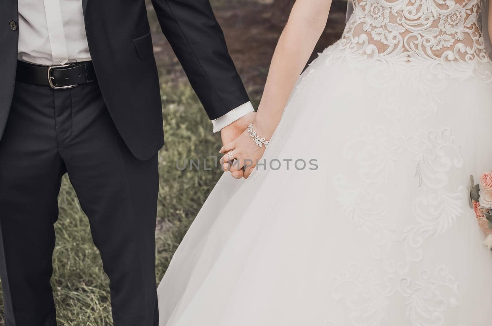 man and woman holding hands. wedding rings bride and groom on the background. Wedding ceremony. Jewelry.