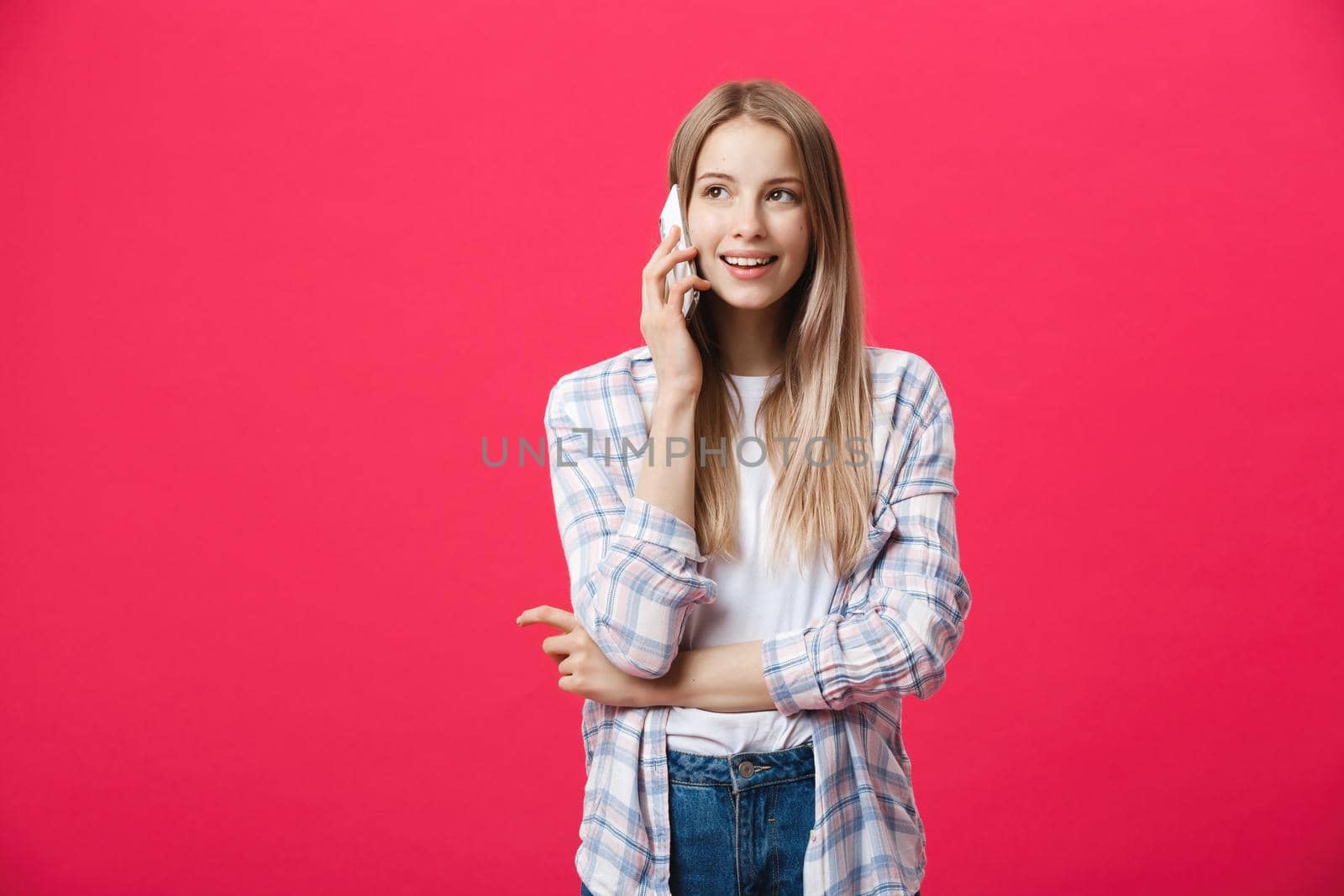 Cheerful young woman talking on mobile phone isolated on pink background by Benzoix