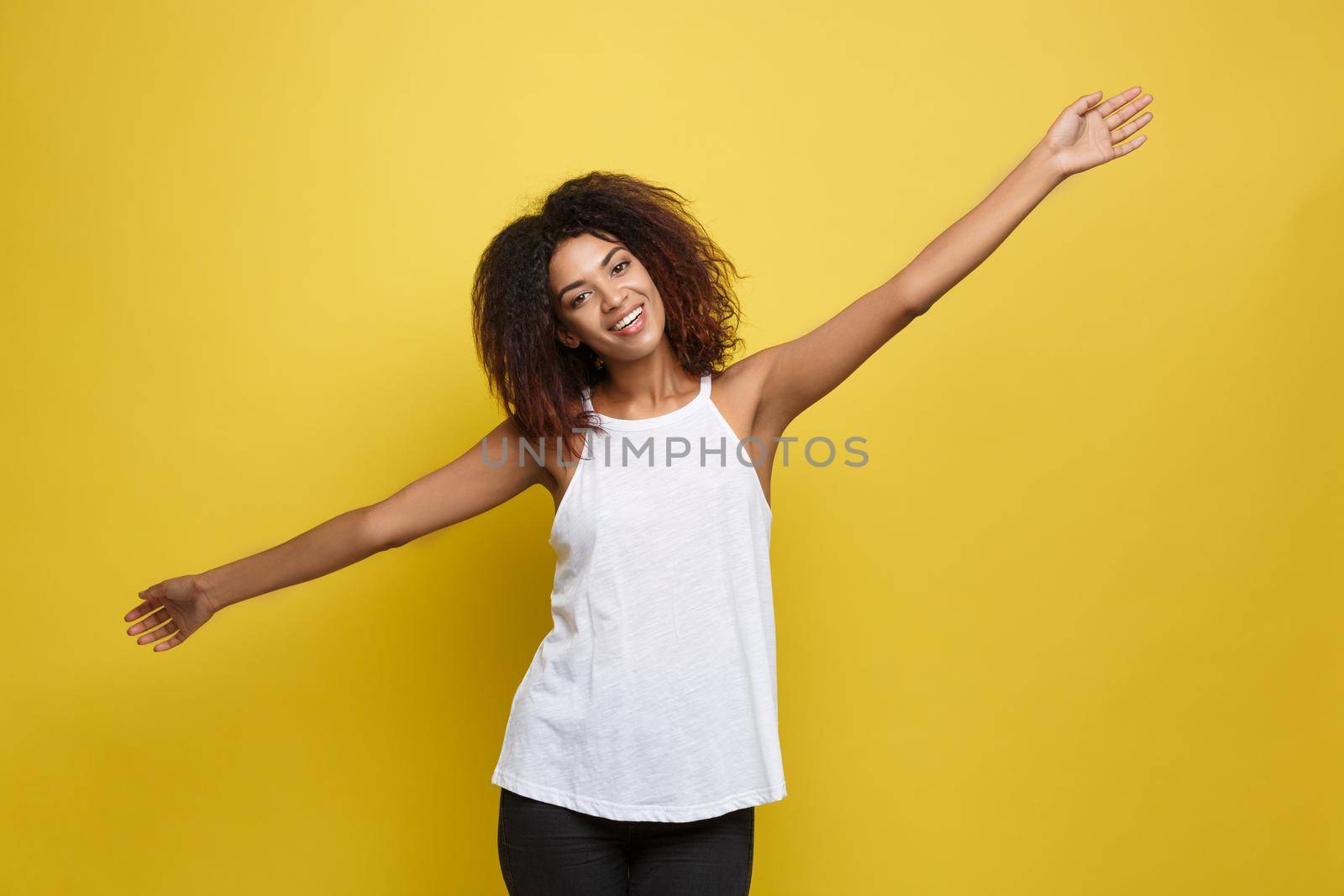 Beautiful attractive African American woman with trendy glasses posting over yellow studio background. Copy Space. by Benzoix