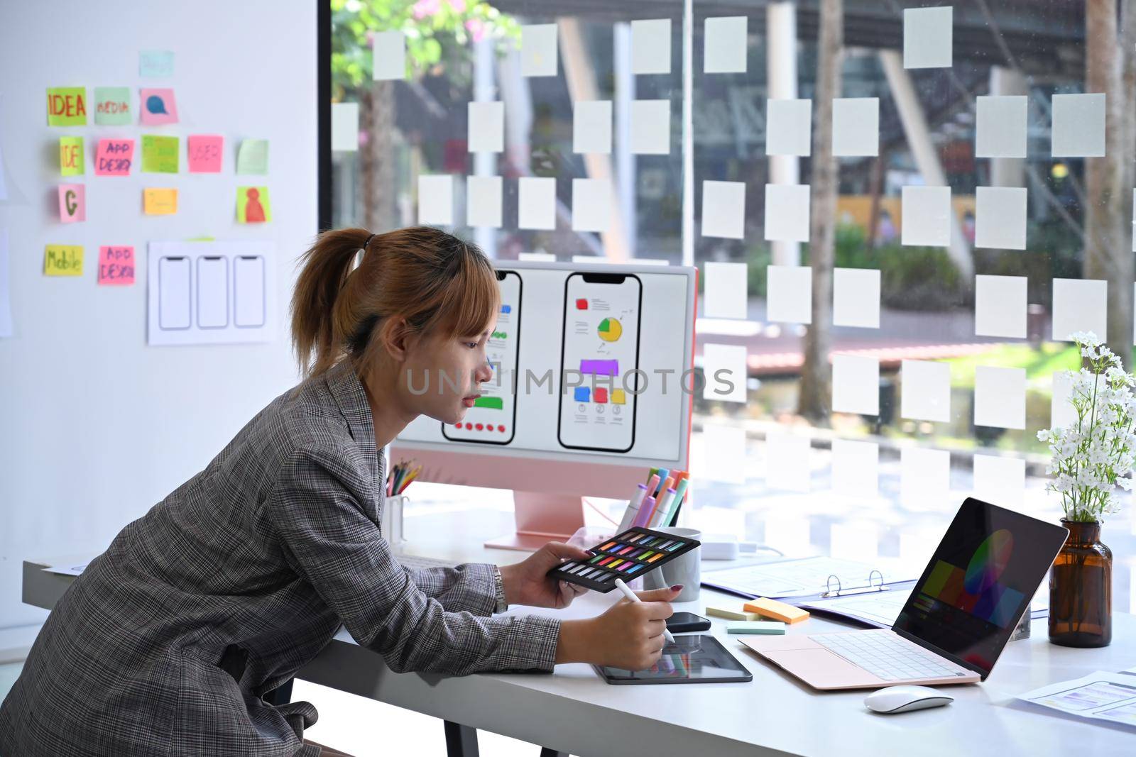 Creative woman is working on application development prototype wireframe for mobile phone.