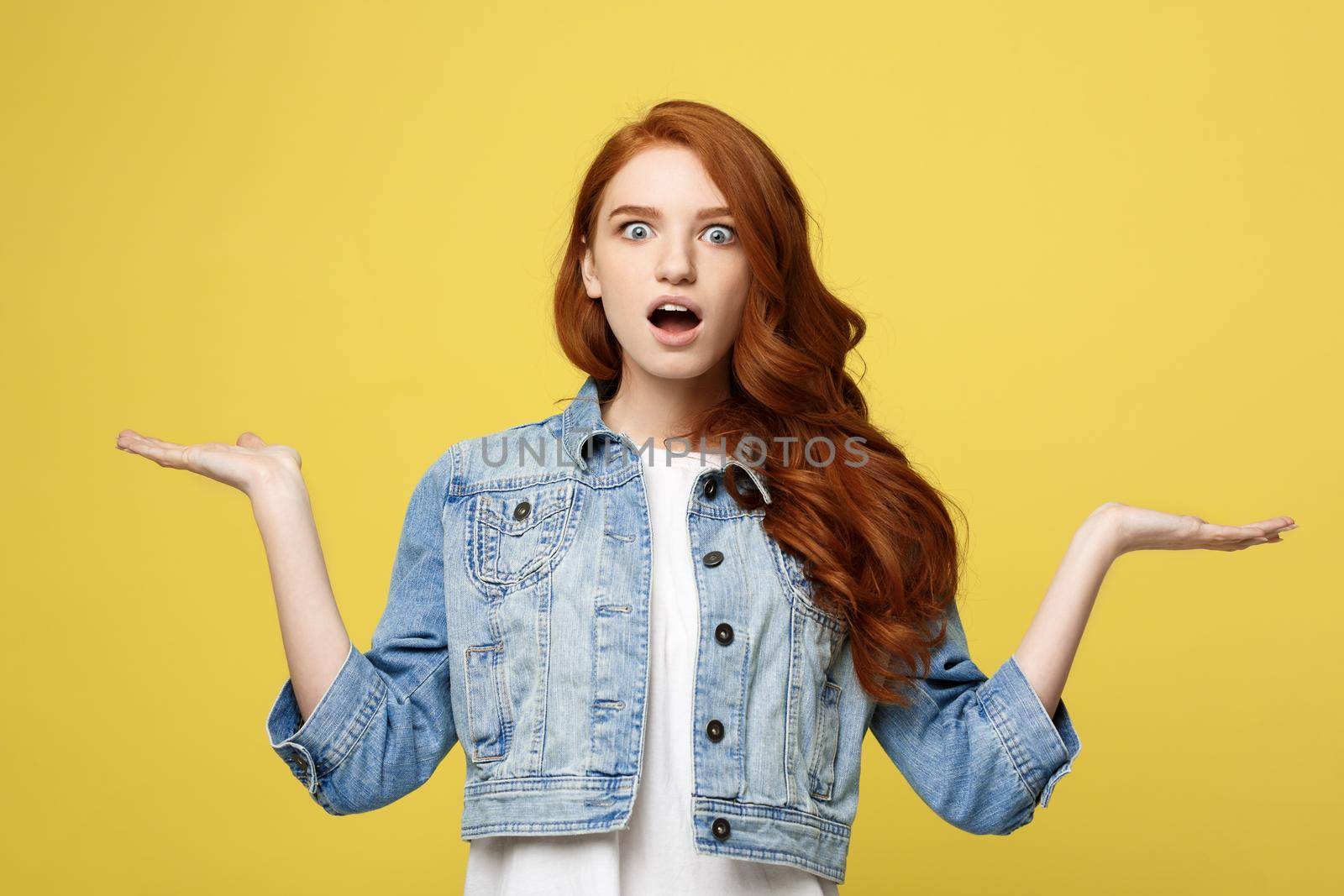 Lifestyle Concept: Surprised young woman with hand on side over golden yellow background. Looking at camera