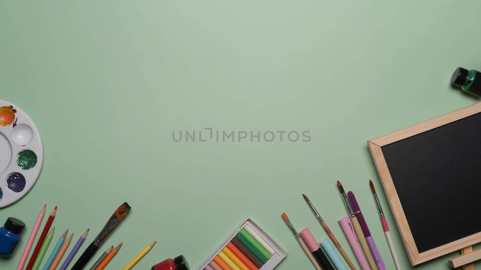 Chalkboard and school stationery on green background. Back to school concept.
