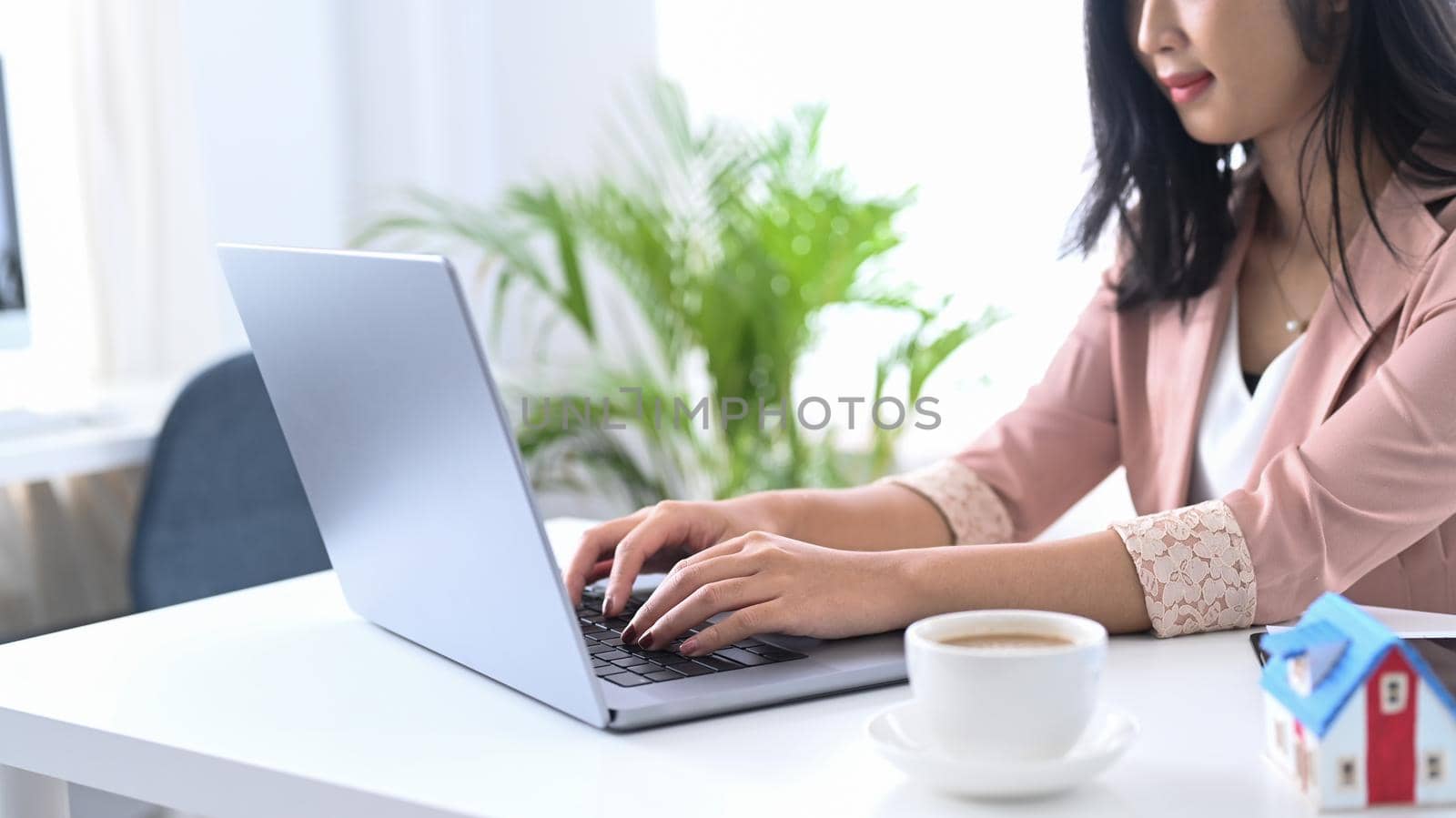 Young woman office worker sitting at her workplace and using laptop computer.
